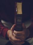 A man sitting and holding a Bible