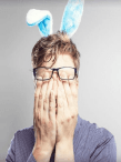 A man wearing bunny ears while rubbing his face in exasperation