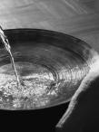 water being poured into a large bowl for foot washing