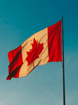 The canadian flag against a clear blue sky