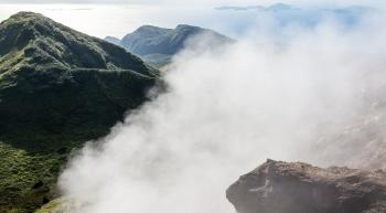 steam wafting from a tropical island mountaintop