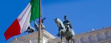 statue of an Italian king near an Italian flag