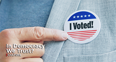 Man wearing jacket with a pin on the lapel saying "I Voted!"