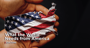 two hands gently holding a small cutout of the United States map. The cutout is decorated with the American flag, displaying its stars and red-and-white stripes.